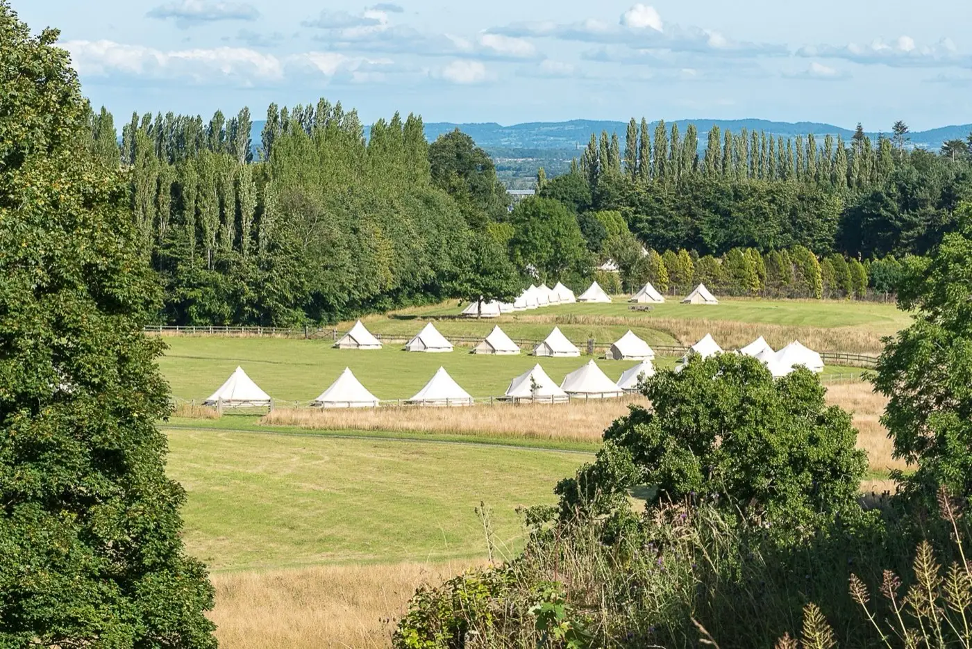 A village of white bell tents in a field
